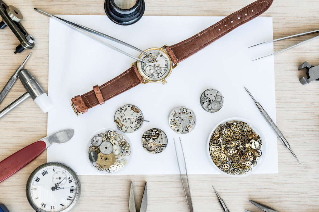 Intricate watch repair and restoration on table. | Rolex watch repair