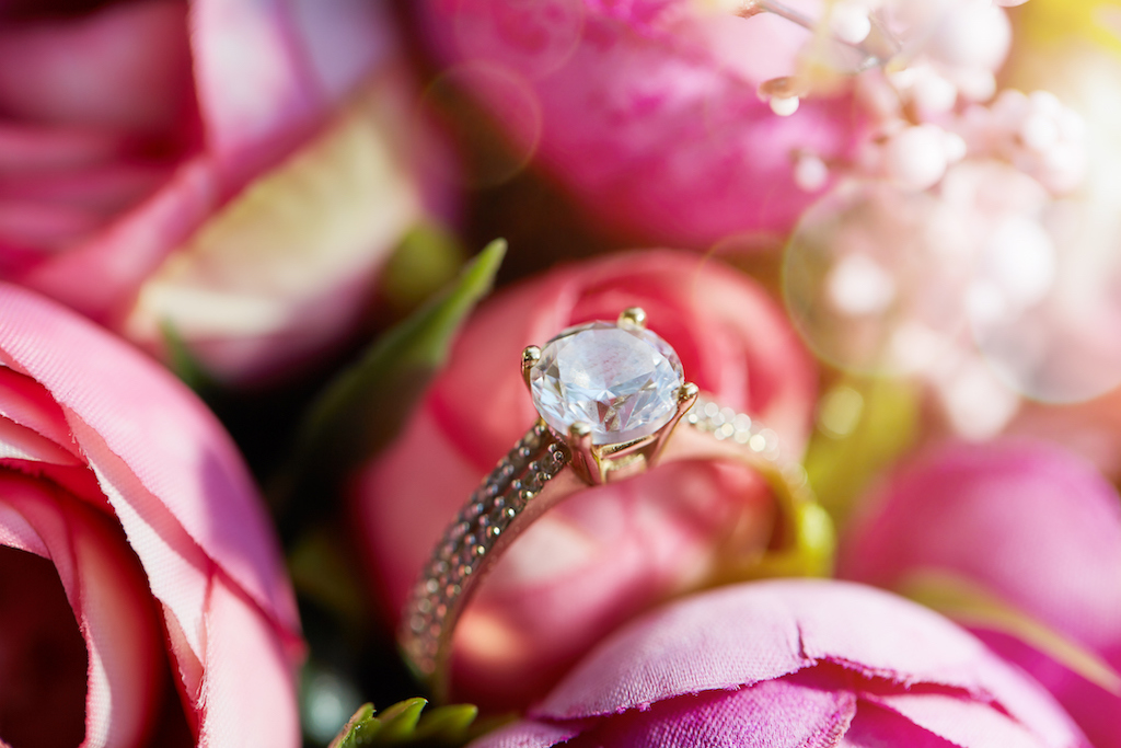 Diamond engagement ring on bouquet of roses. In need of wedding ring engraving