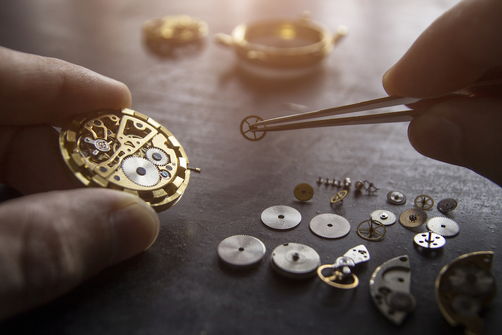 Person performing Vintage Watch Restoration with small pieces.